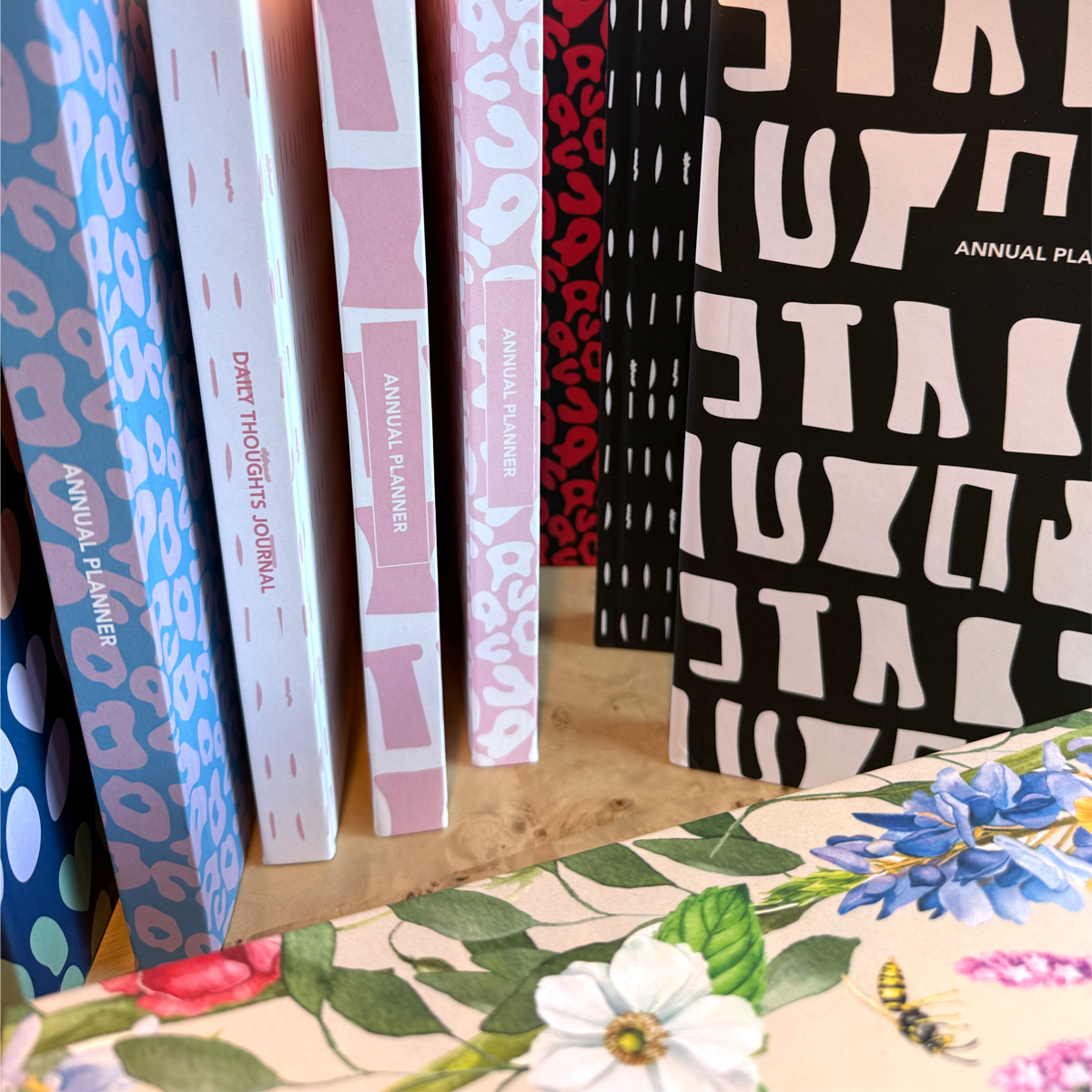Collection of beautiful patterned journals and planners on a desk.