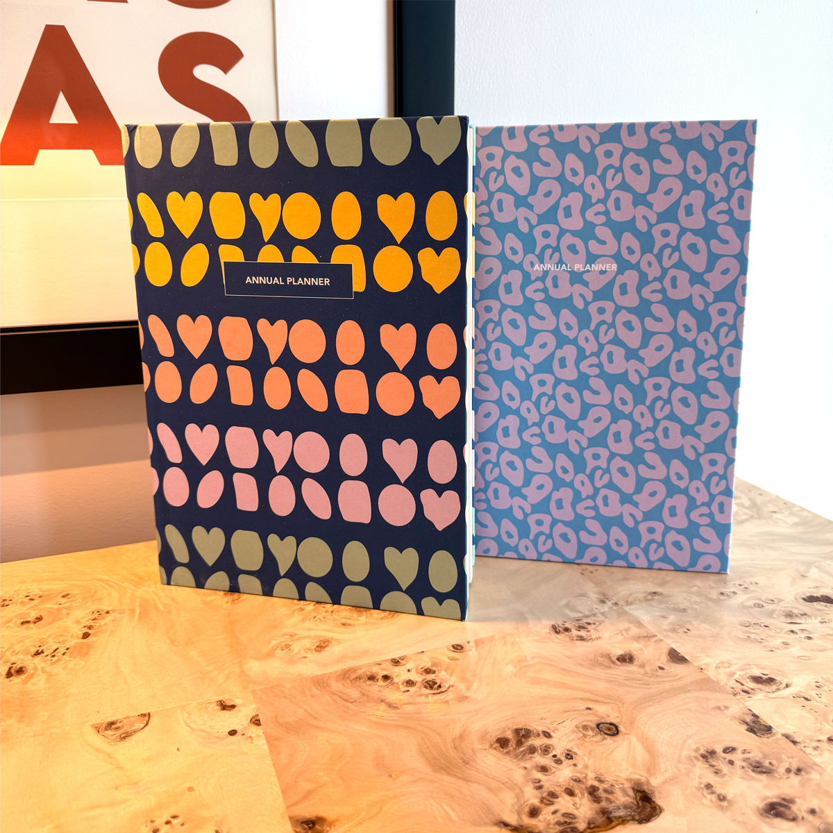 Two planners with colorful heart patterns on a desk