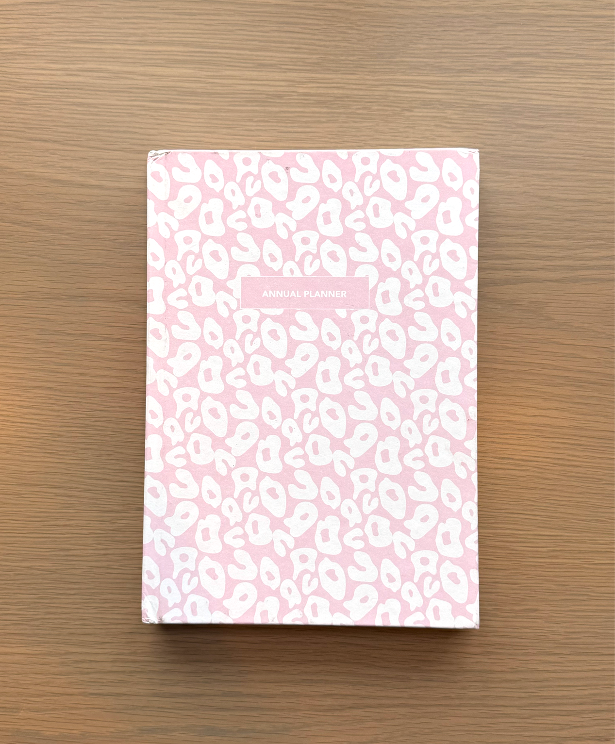 Pink Leopard Print Planner on a coffee table