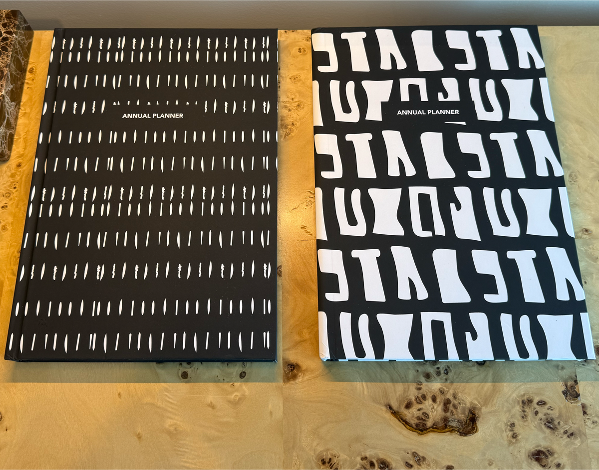 Two planners with different cover designs on a wooden surface