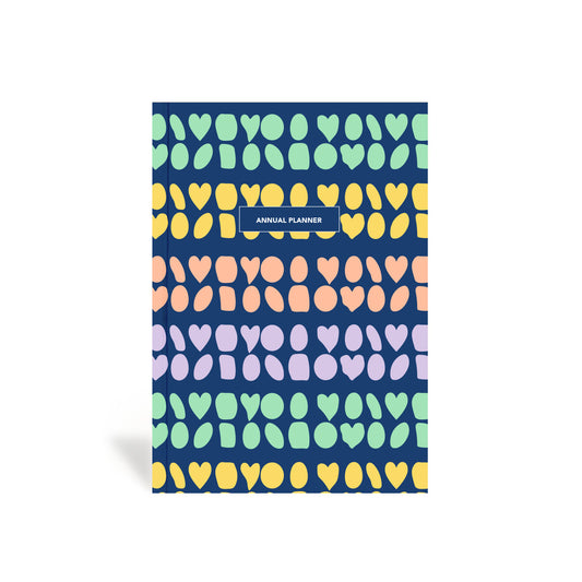 A colorful planner with a geometric pattern of hearts and abstract geo circles on the cover.